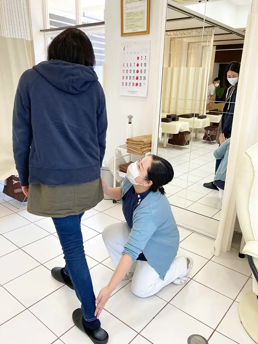 巻き爪再発予防のために歩き方を指導するフットケアセラピスト